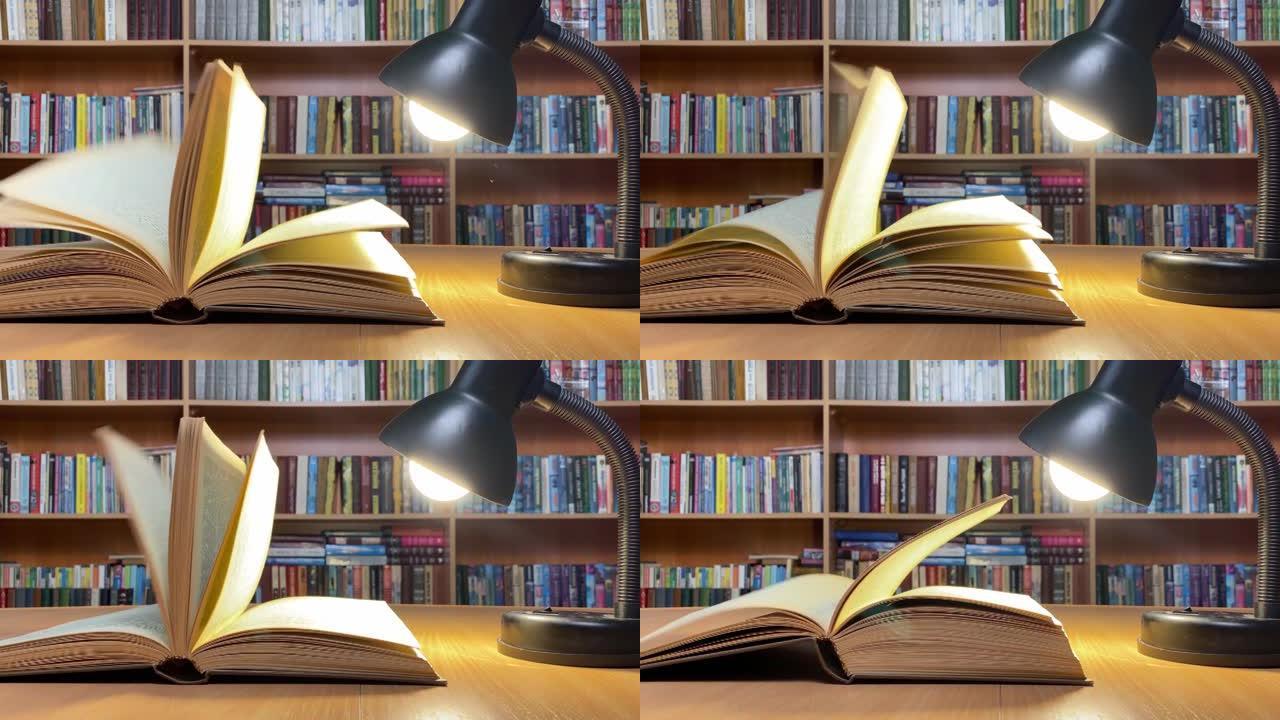 在经典图书馆的灯下在木制桌子上预订。风翻页。书架。