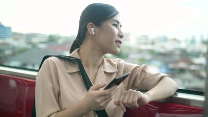 年轻迷人的女人戴着无线耳机，在火车上旅行时听音乐