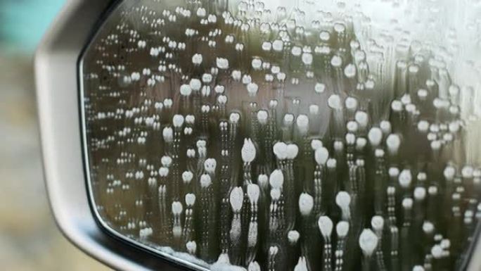 玻璃清洁剂泡沫从驾驶员盲点监控后视镜中排出