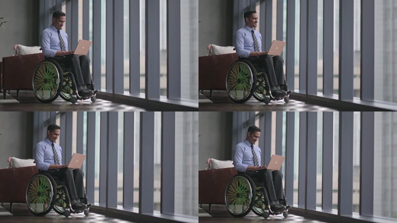 在休息区使用笔记本电脑微笑禁用轮椅上的亚洲印度男性白领