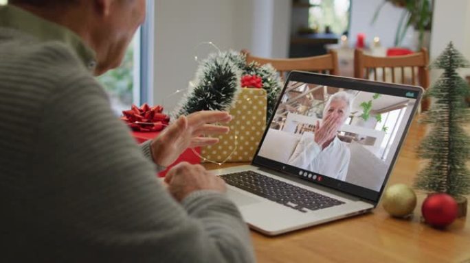 快乐的高加索高级男子在圣诞节与高级女性朋友在笔记本电脑上进行视频通话