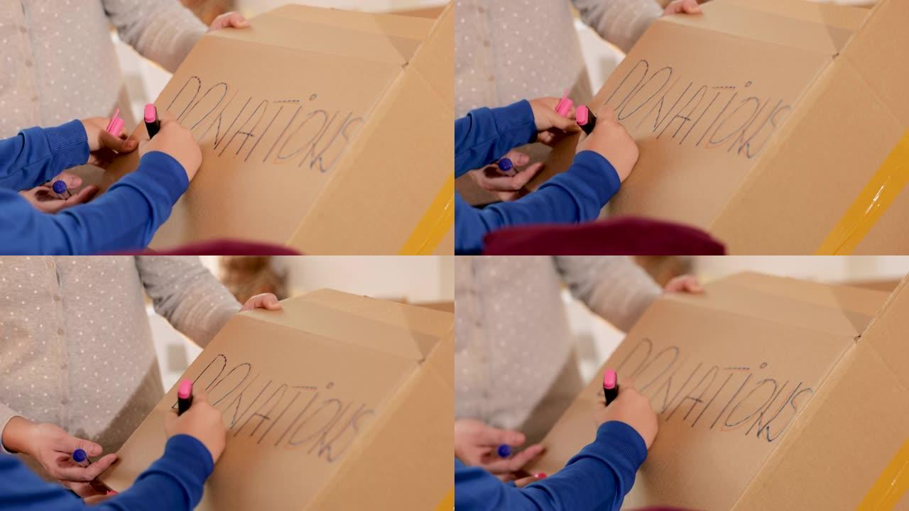 男孩在cradborad盒子上用记号笔书写 “捐赠”
