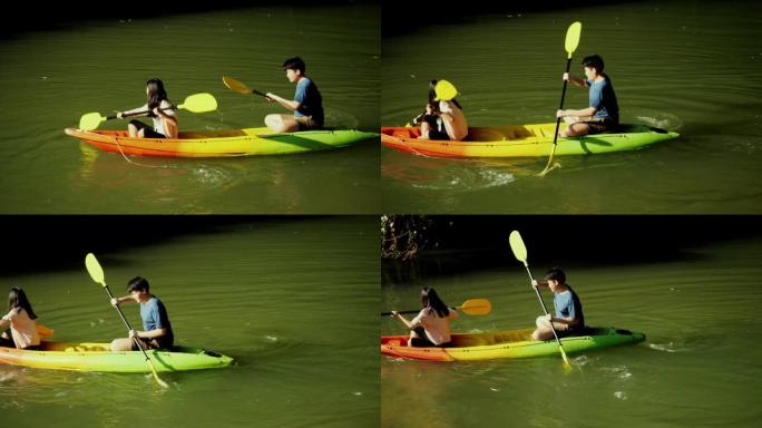 快乐的亚洲儿童在阳光明媚的日子里一起在河里划独木舟，生活方式理念。