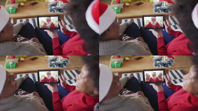 非裔美国母亲和女儿使用平板电脑与屏幕上的圣诞老人进行圣诞节视频通话