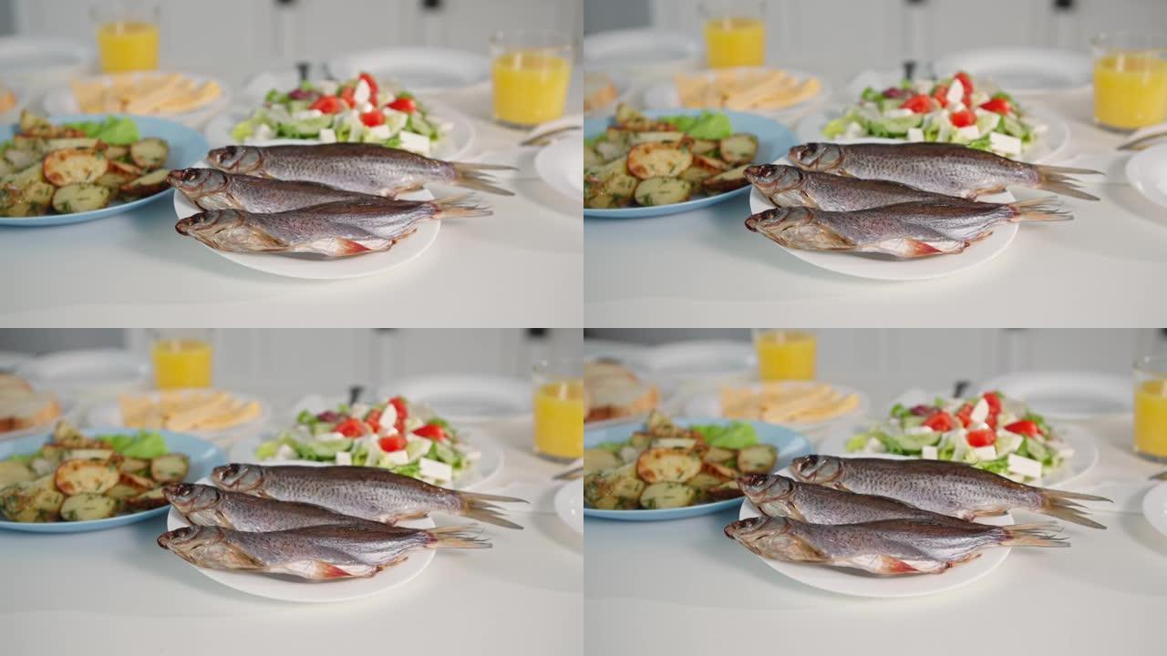 海鲜，美味的鲜鱼放在桌子上的沙拉和炸土豆附近的盘子上，特写