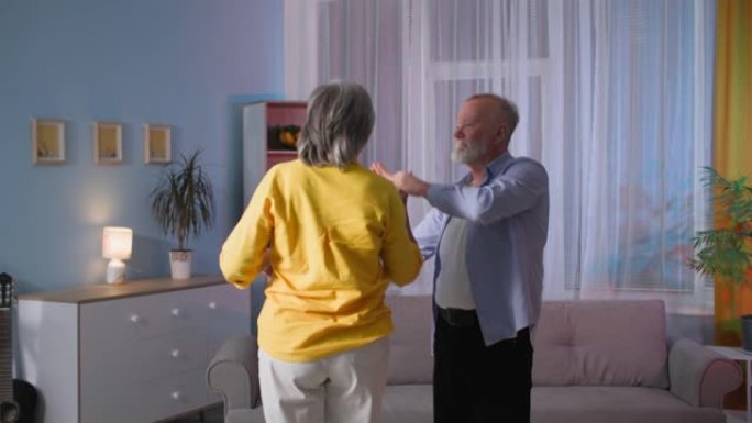 跳舞的老年夫妇的肖像，充满爱心的丈夫在家里与妻子一起玩，祖父母一起享受生活
