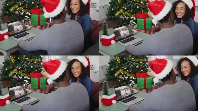 圣诞节时，快乐的非洲裔美国夫妇在笔记本电脑上与戴着圣诞老人帽子的男孩进行视频通话