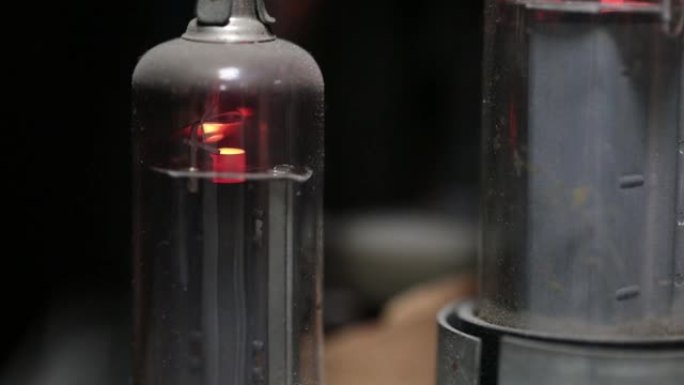 旧管式电视中的真空管在工作状态下尘土飞扬。20世纪技术的内部结构