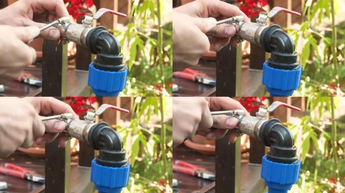 管道工在花园区域连接潜水泵时安装软管夹的特写镜头。室外管道维修。水管用软管夹夹紧。