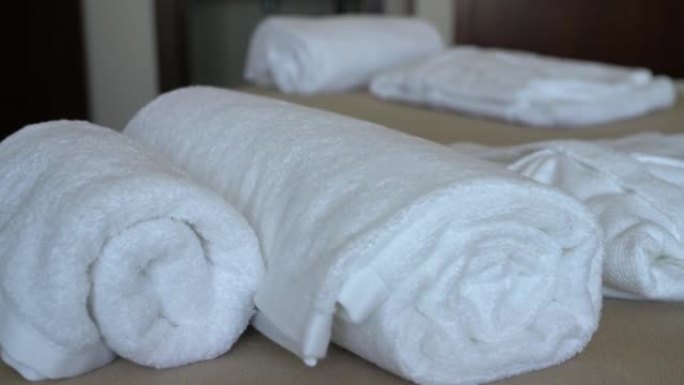 酒店带床和枕头的现代卧室房间的视频拍摄。还有白色毛巾和长袍给招待所游客。特写。