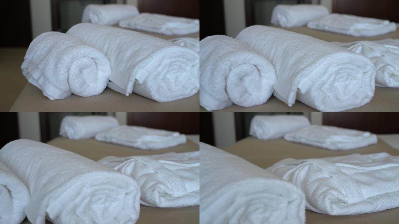 酒店带床和枕头的现代卧室房间的视频拍摄。还有白色毛巾和长袍给招待所游客。特写。
