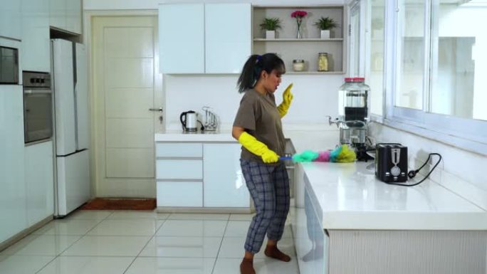 女人用鸡毛掸子打扫厨房