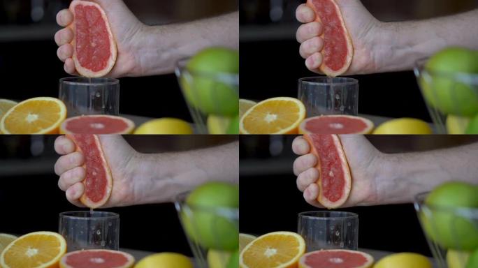 男性的手正在挤压成熟的葡萄柚，以制作柑橘汁，健康的生活方式，果汁