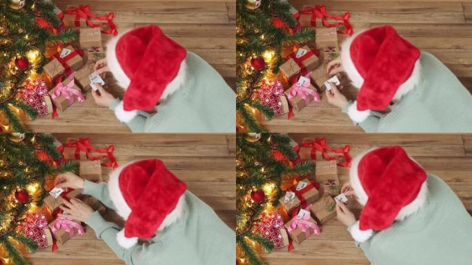 写圣诞贺卡礼物枞树下的女性红帽子礼物