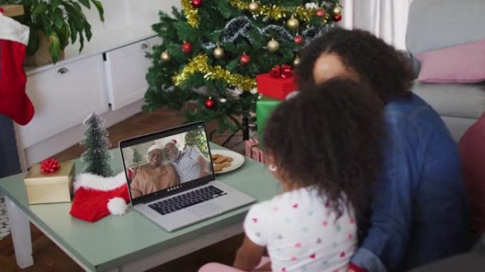 圣诞节期间，与祖父母在笔记本电脑上进行视频通话的非洲裔美国母女快乐