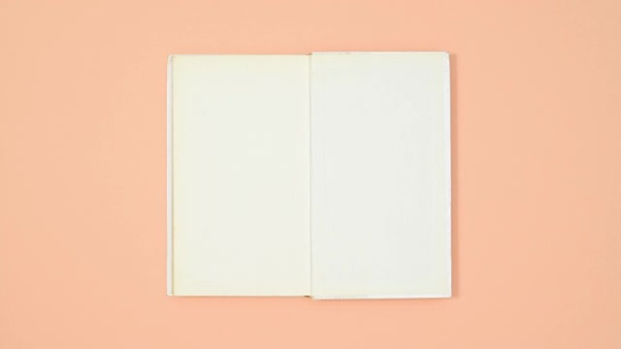 白色精装书从包装纸上出现，并以橙色主题打开。停止运动平铺