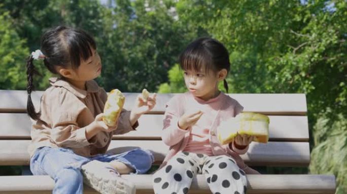 在公园野餐，孩子们吃面包