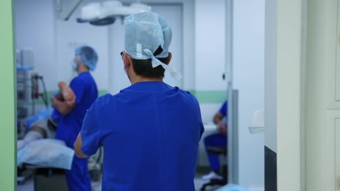 专业外科医生走进手术室。医生在手术前给他的手臂消毒。慢动作。