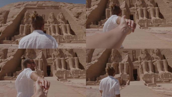 跟随我的概念: 年轻男子牵着女友的手带领着通往埃及美丽的寺庙