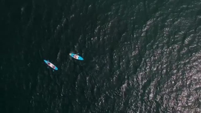 人们在公海的蓝色皮划艇上，从高处看