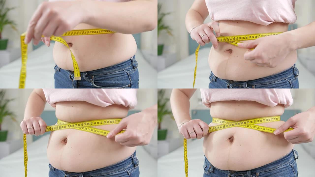 肥胖妇女用黄色卷尺测量大肚子的特写镜头。节食的概念，不健康的生活方式，超重和肥胖