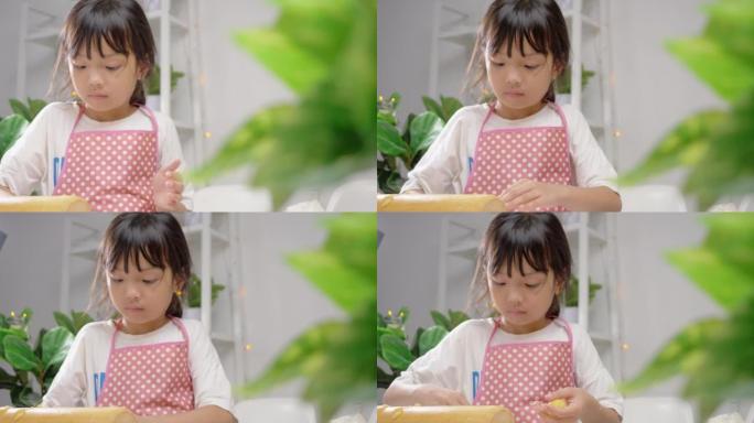 亚洲女孩使用饼干切割器成型自制饼干庆祝圣诞节，生活方式概念。