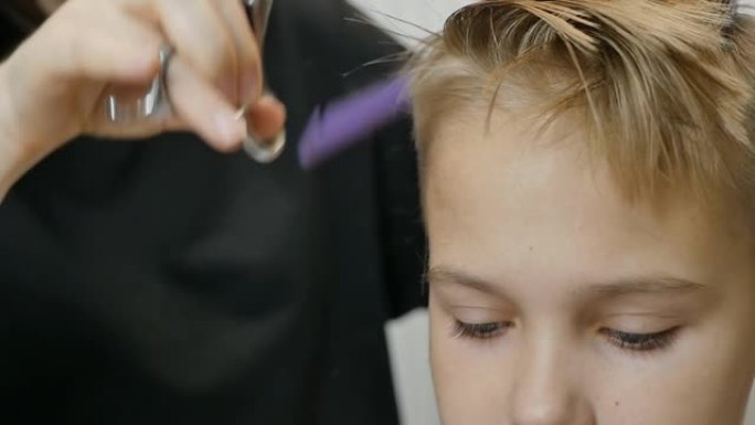 理发师用稀疏的剪刀和梳子为十几岁的女孩剪头发