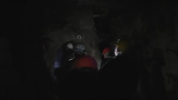 一群游客探索黑暗的矿井隧道