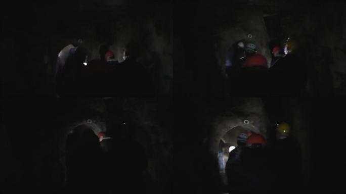 一群游客探索黑暗的矿井隧道