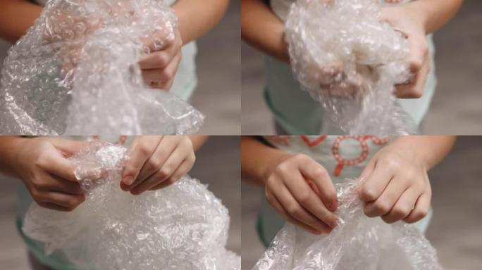 小女孩用手指从包装中破裂气泡。气泡包装代替旋转器，粘液并弹出。女孩按泡泡包装。压力概念