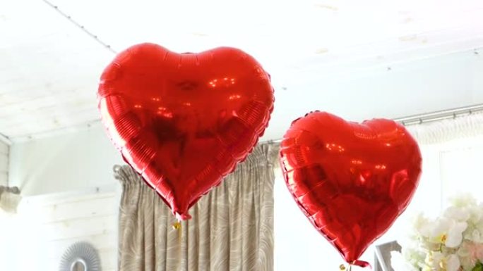 用白色人造花和红色心形气球装饰宴会厅。