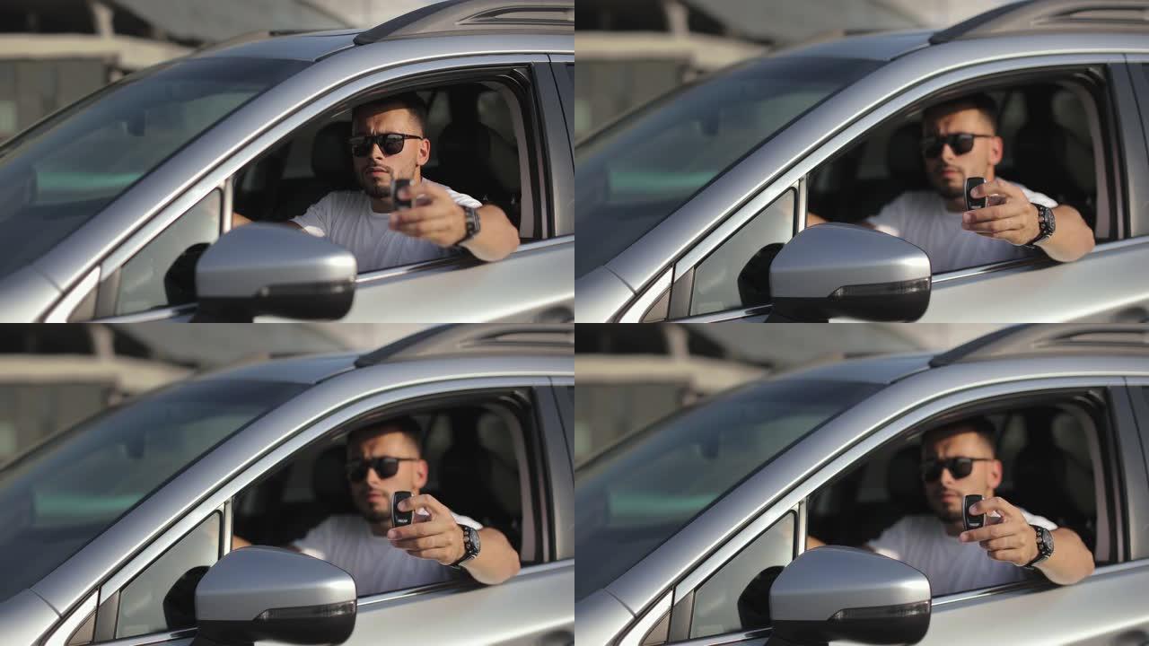 这个人坐在驾驶座上的车里。他正在看摄像机，并展示汽车钥匙。关注关键。他戴着墨镜。4K