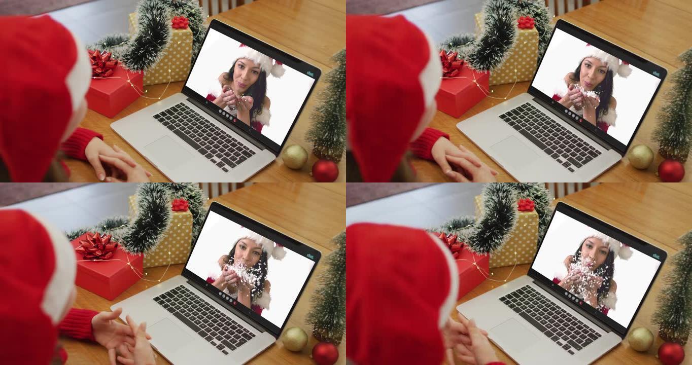 圣诞节时，白人妇女与女性朋友在笔记本电脑上进行视频通话