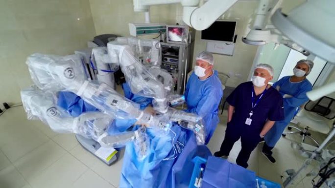 当代手术室的机器人手术。在微创手术期间，一组医学专家站在机器人机器附近。顶视图。