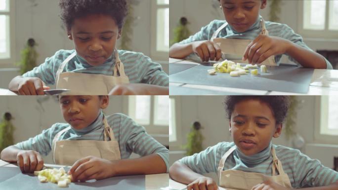 小男孩在烹饪大师课上切梨和吃梨