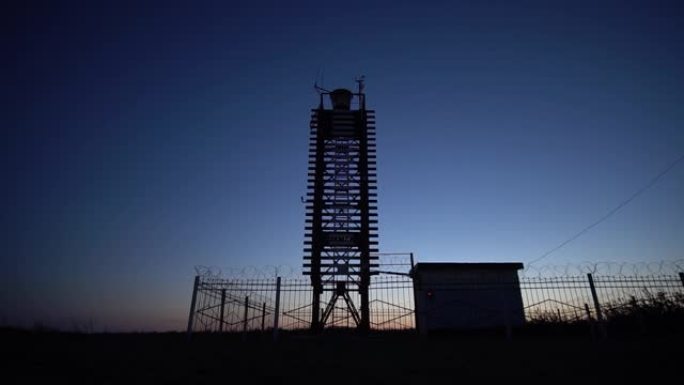 黄昏时天空背景上的一座新木制灯塔的轮廓。延时。