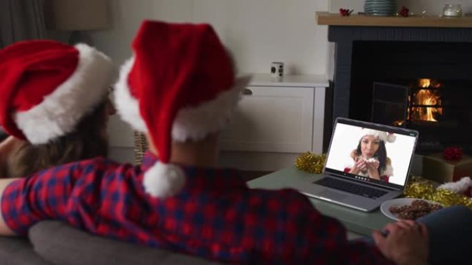 圣诞节时，快乐的高加索夫妇与女性朋友在笔记本电脑上进行视频通话