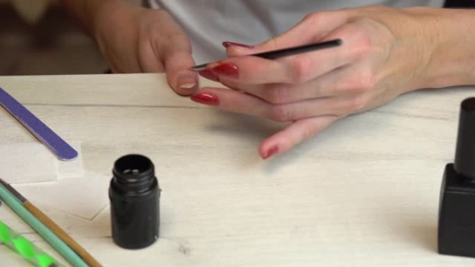 在家进行自我修指甲，在用指甲油涂指甲之前先涂底涂层
