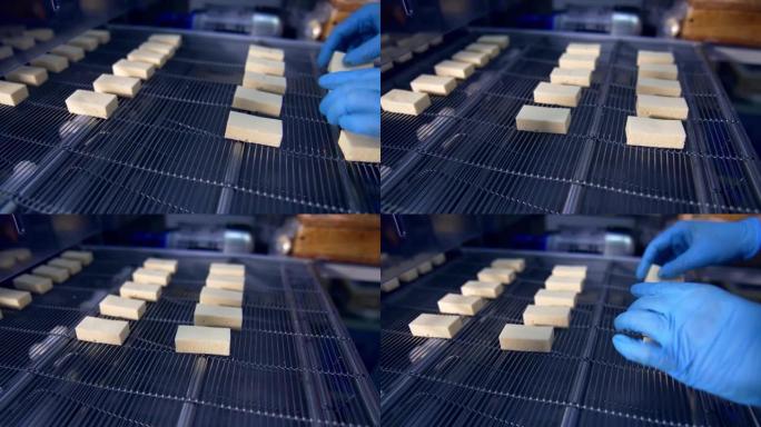 工厂工人将白色糖果放在传送带上。糖果厂生产糖果。小糖果的特写。