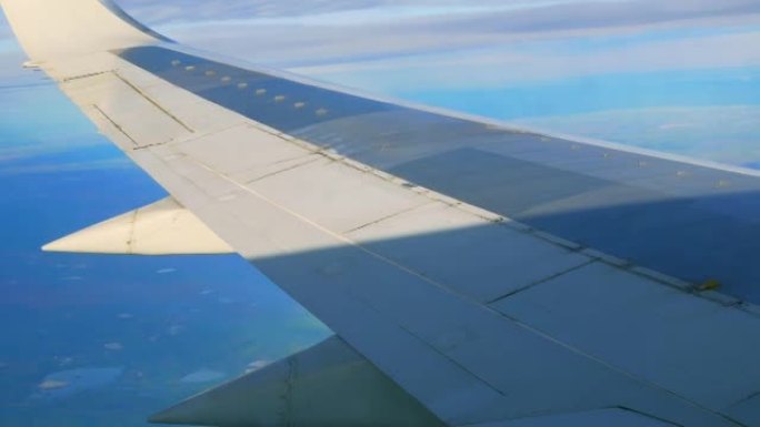 一架掉头的客机机翼的特写镜头。从乘客座椅上的eluminator看到衬板翼。通过乘客的眼睛在飞机上飞
