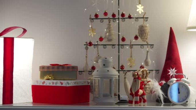 圣诞礼物之间的金属圣诞树，发光的红白礼品盒装饰照明，经典闹钟。新年时间。圣诞快乐。假日季节。