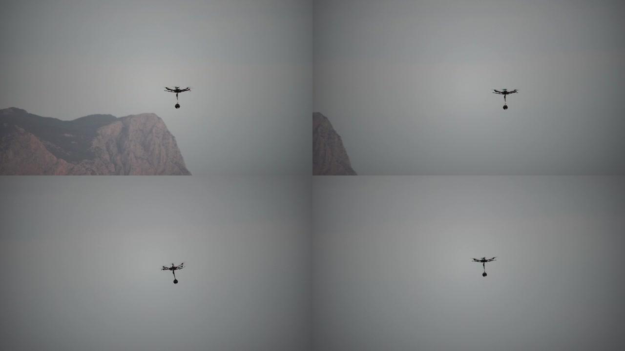 专业摄影无人机直升机的轮廓，全景摄像机在空中飞行。海上日落的空中全景。日落时的车辆和复印空间