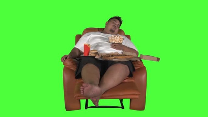 狼吞虎咽的肥胖男子睡在沙发上