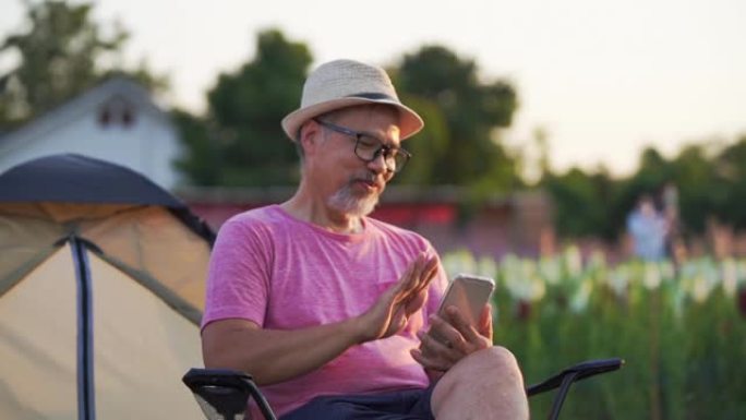 中年男子通过坐在花园里的电话访问在线约会网站，专注于手