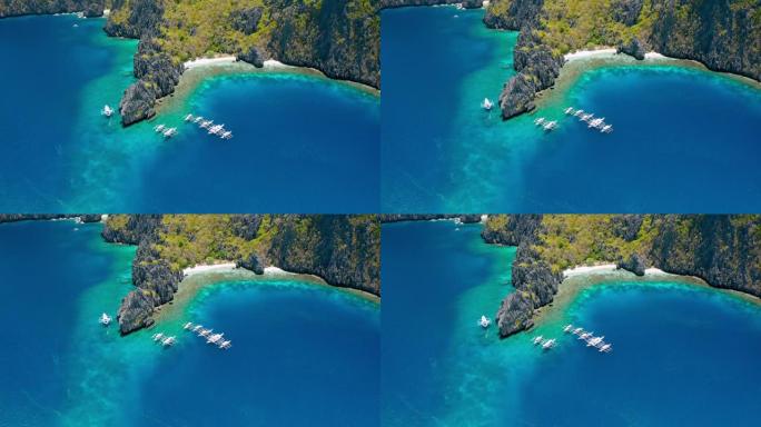 米尼洛克岛秘密泻湖附近潜水船的鸟瞰图。巴拉望爱尼多。菲律宾。奇异的石灰岩岩层和带有珊瑚礁的蓝色泻湖使