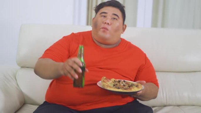 超重男子吃披萨喝啤酒