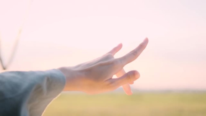 自由女孩的手从窗外骑着汽车风迎面。概念车在路上旅行。女孩伸出她的手走出车窗阳光刺眼的夕阳。快乐和自由