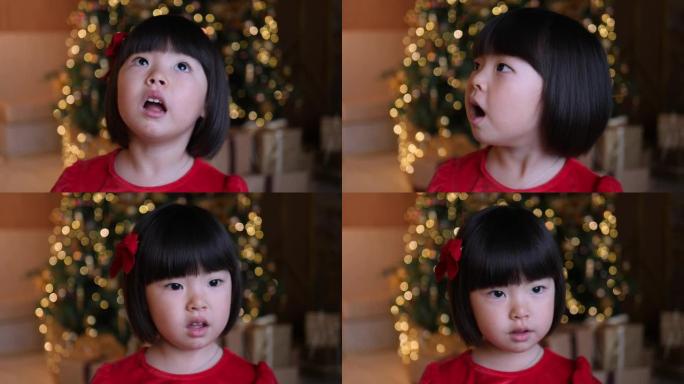 穿着红色连衣裙的韩国女童站在新年圣诞树上