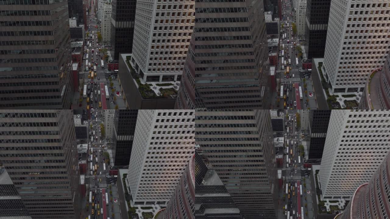 上升倾斜向下拍摄宽阔的单向街道，周围是高大的现代办公楼或公寓楼。在大道上行驶的车辆。美国纽约市曼哈顿