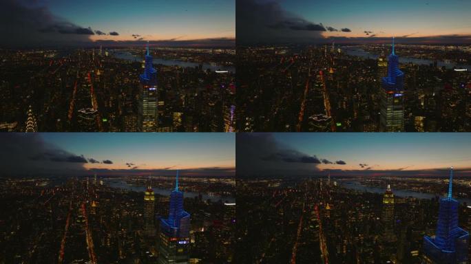 黄昏时，前锋在市中心上空飞行。带有照明摩天大楼的夜景城市景观的惊人鸟瞰图。美国纽约市曼哈顿